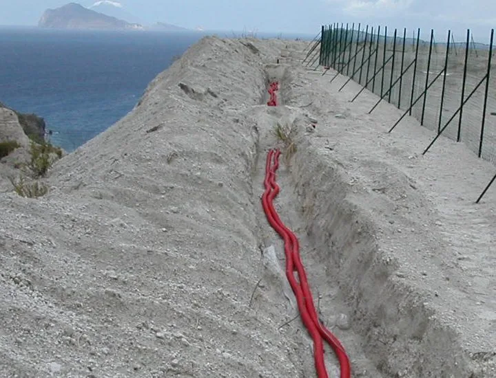 Posa cavi elettrici in trincea su costone con vista mare